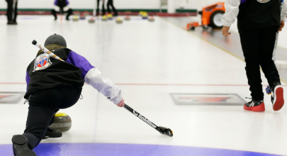 A Team Yukon curler leaves the hack